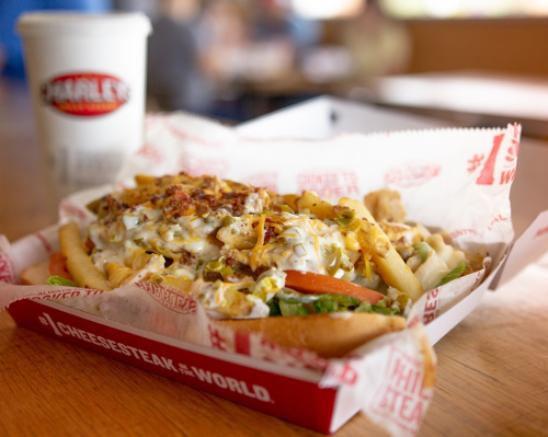 Charley's Philly Cheese steak fries and soft drink.