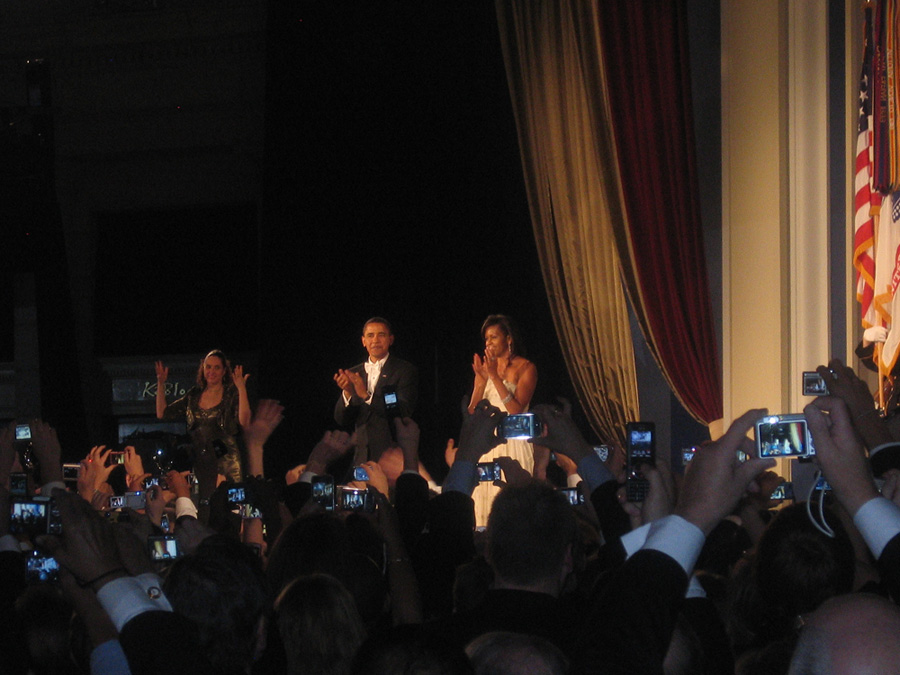 President Obama and First Lady Michelle on state in front of a crowd.