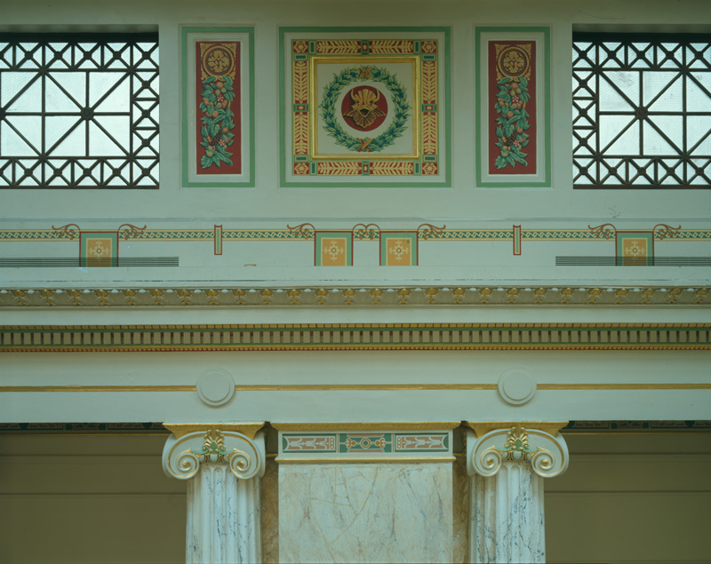 East Hall frieze, gold, red, and green, with a laurel and vines.