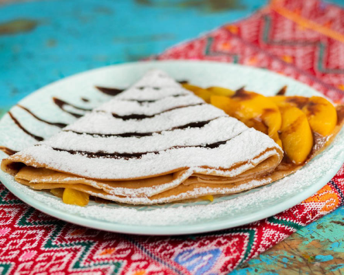 Crepe Lena crepe with mangos and powdered sugar.