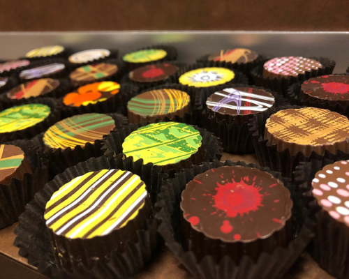 Neuhaus Chocolatier array of chocolates decorated with various colors such as red, green, orange, etc.