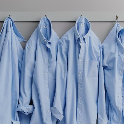 UNIQLO Blue collar shirts hanging in a row.